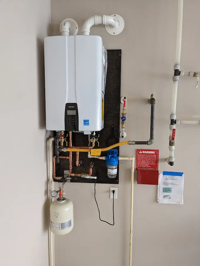 Professional plumber installing copper piping in a Godfrey home